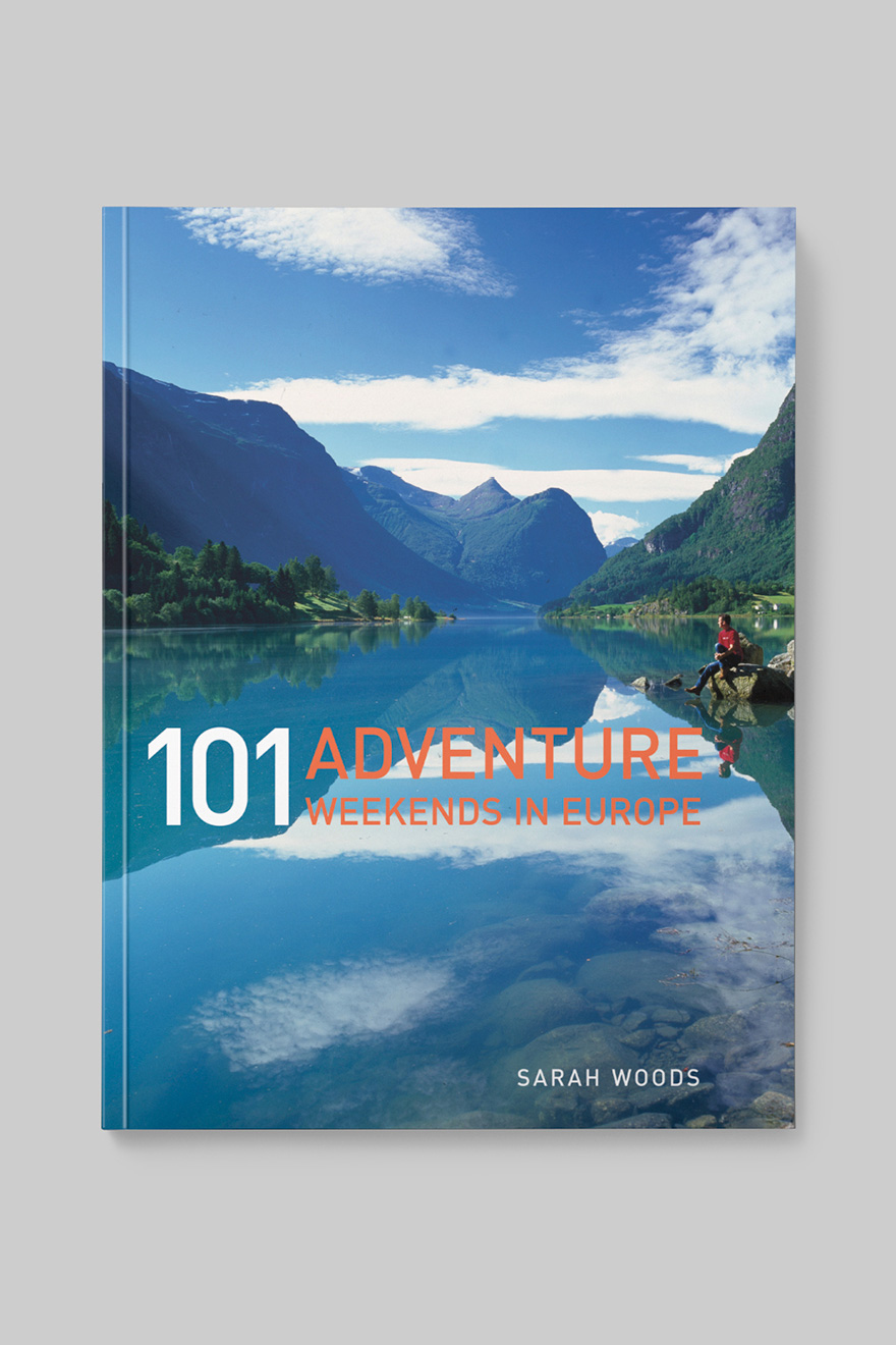Front book cover to 101 Adventure Weekends in Europe, showing a hiker sitting next to a lake
